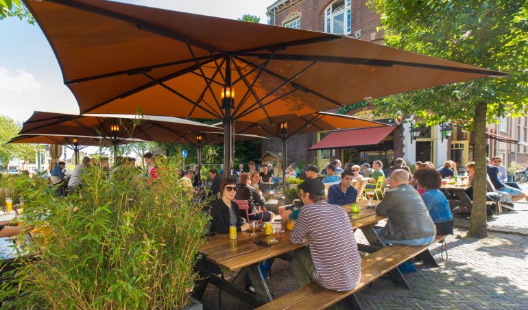 Cafe Ledig Erf terras met mensen in de zomer.