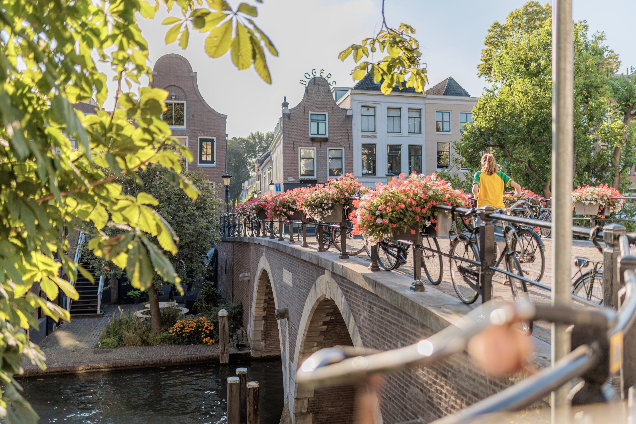 Meisje op de fiets op brug over de Oudegracht in Utrecht