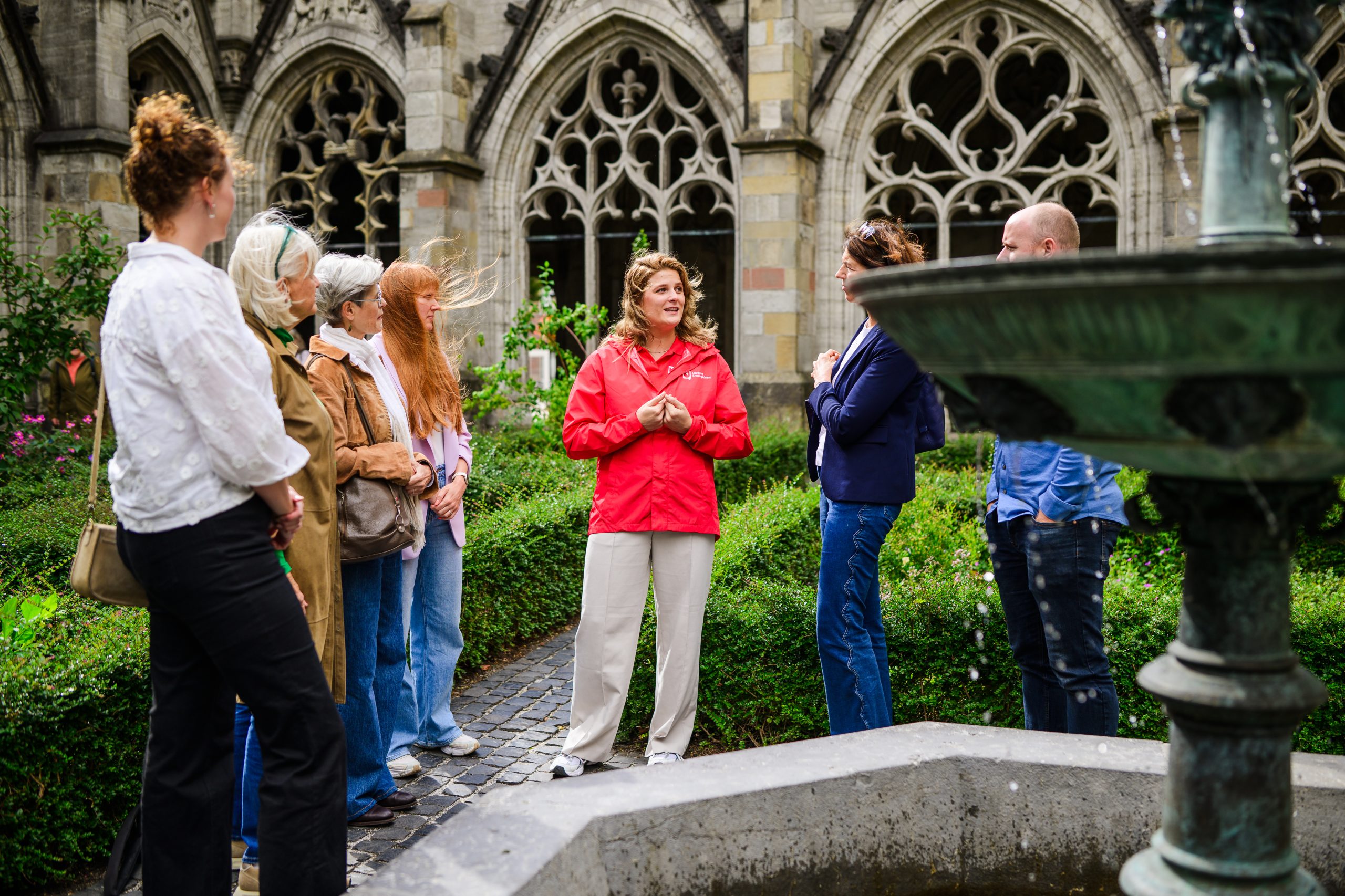 Een stadsgids leidt een groep rond in de Pandhof naast de Domkerk