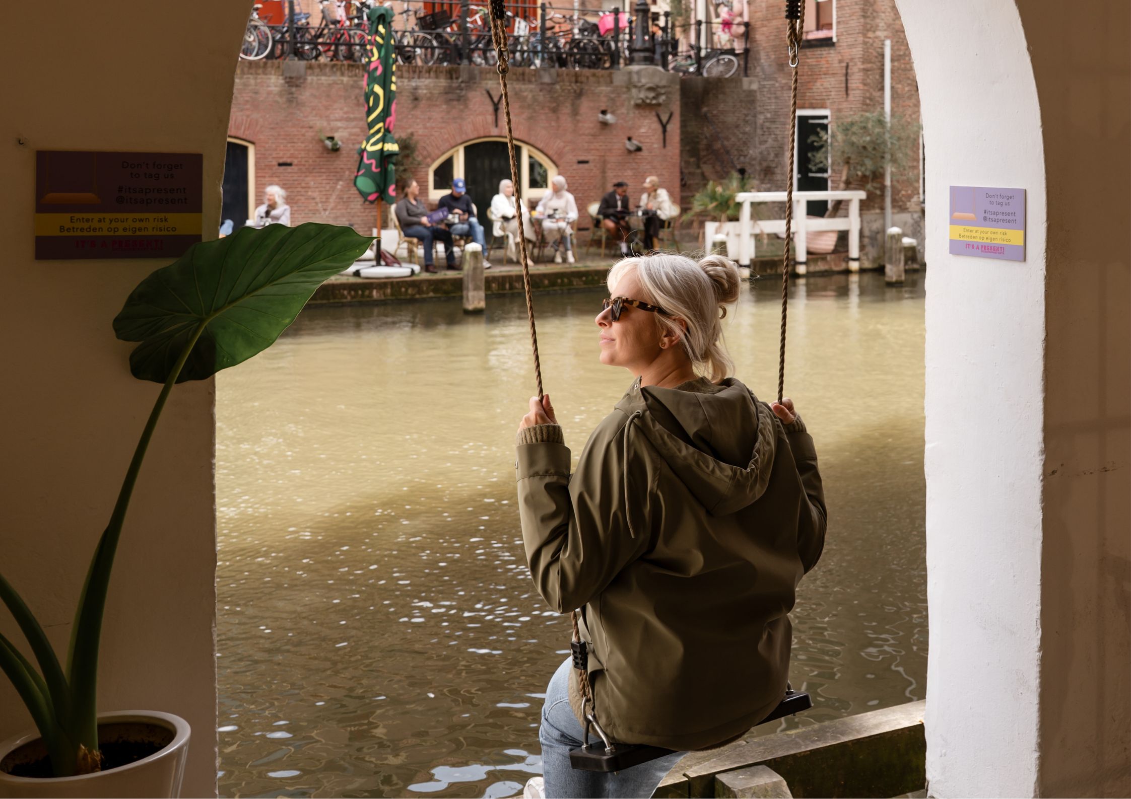 Vrouw zit op schommel aan de Oudegracht